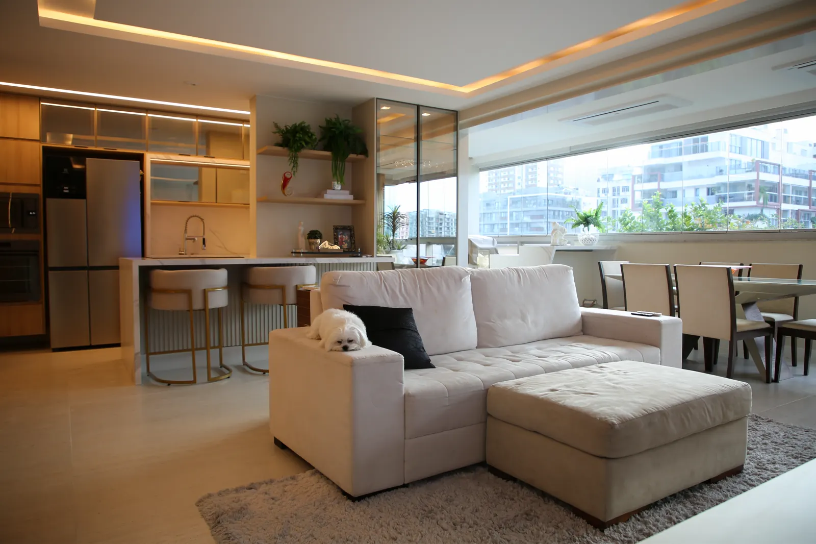 Sala integrada com varanda, vista urbana e cozinha gourmet com bancada