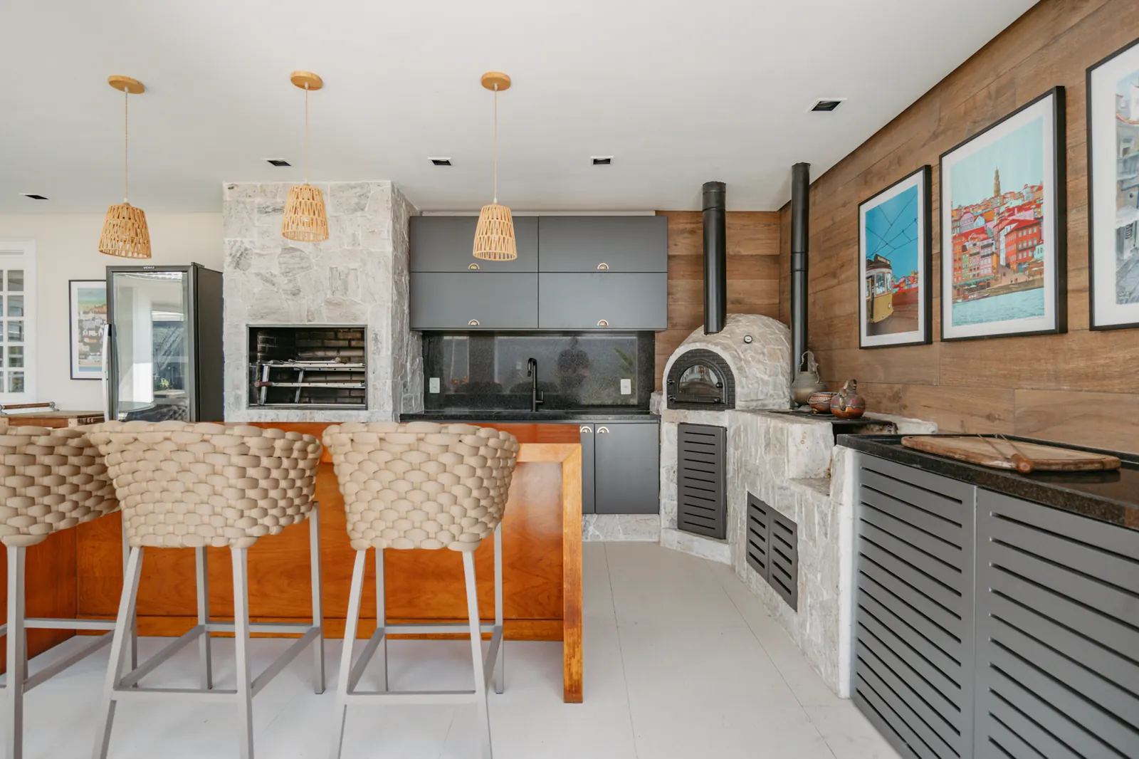 Cozinha gourmet com forno a lenha em pedra natural e marcenaria cinza
